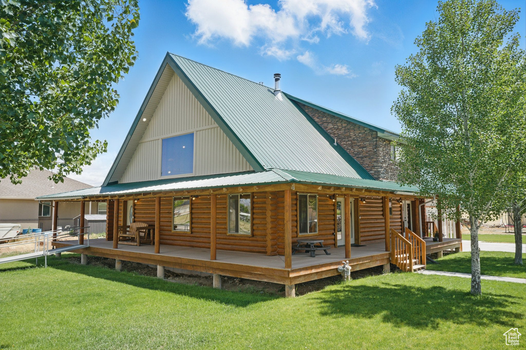 Rear view of property with a yard and a metal roof