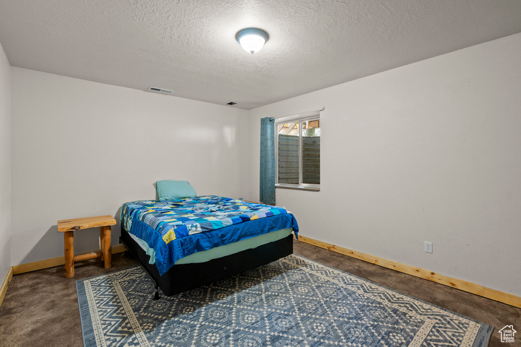 Bedroom featuring baseboards and a textured ceiling