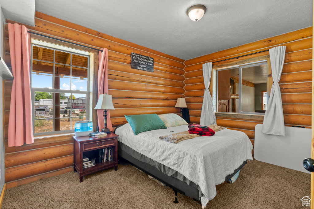 Carpeted bedroom with rustic walls