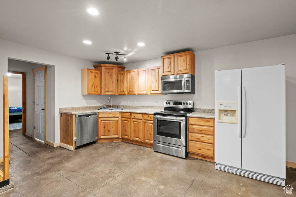 Kitchen featuring stainless steel appliances, concrete flooring, light countertops, and recessed lighting