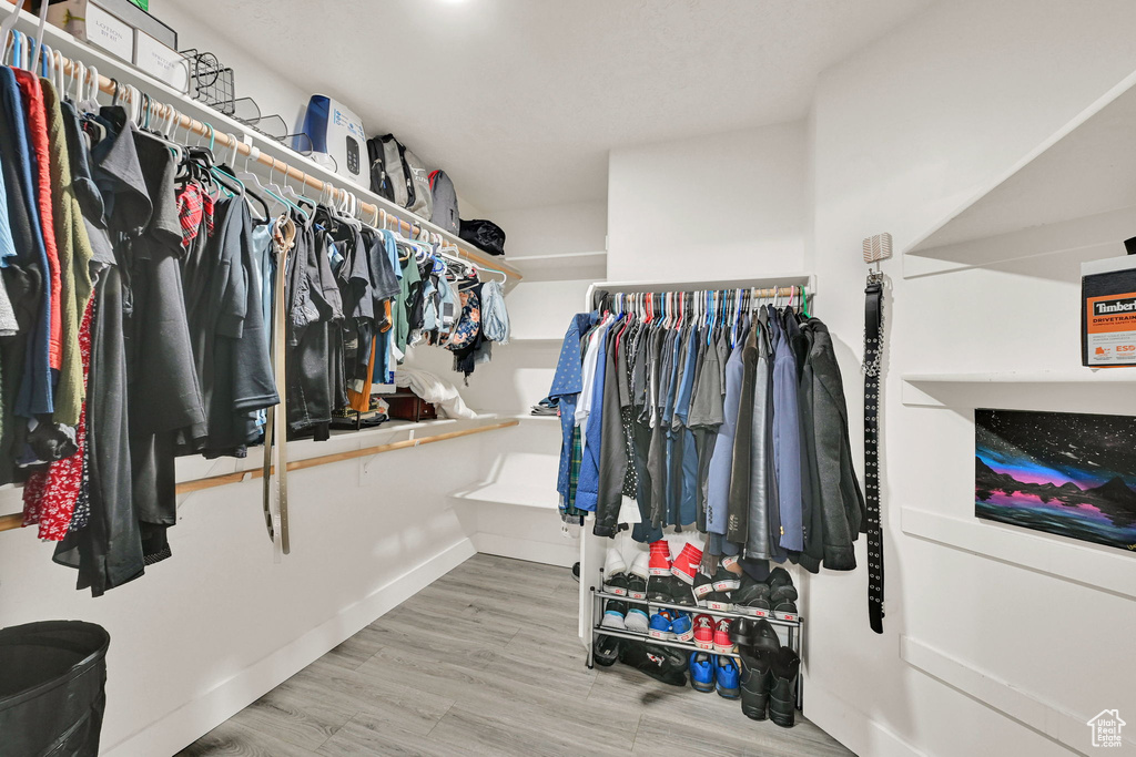 Walk in closet with wood finished floors