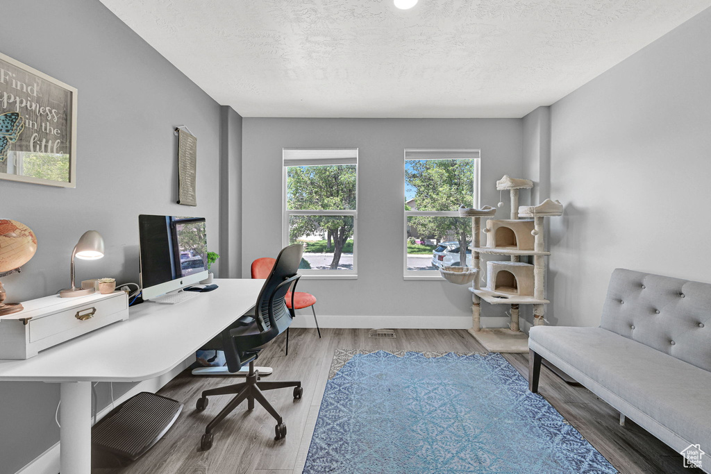 Office area featuring wood finished floors and a textured ceiling