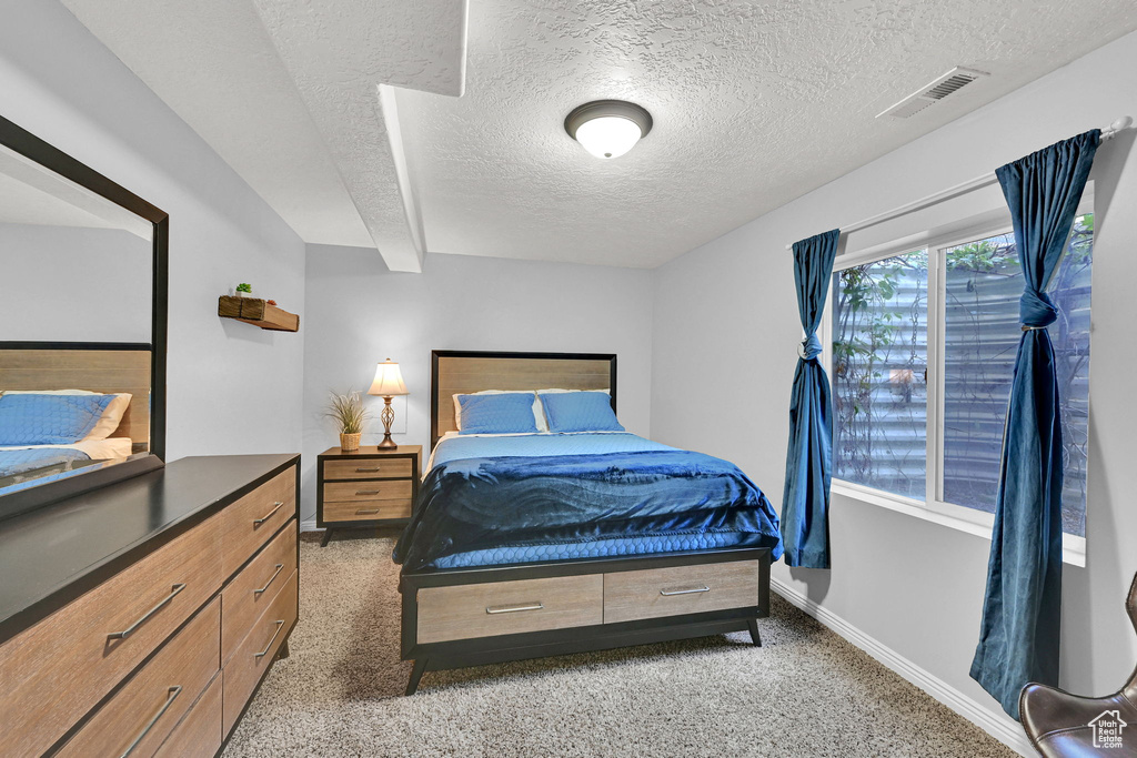 Bedroom featuring a textured ceiling and light carpet