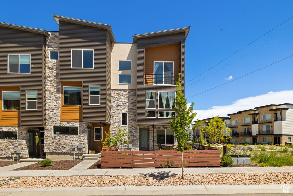 View of front facade featuring stone siding and stucco siding