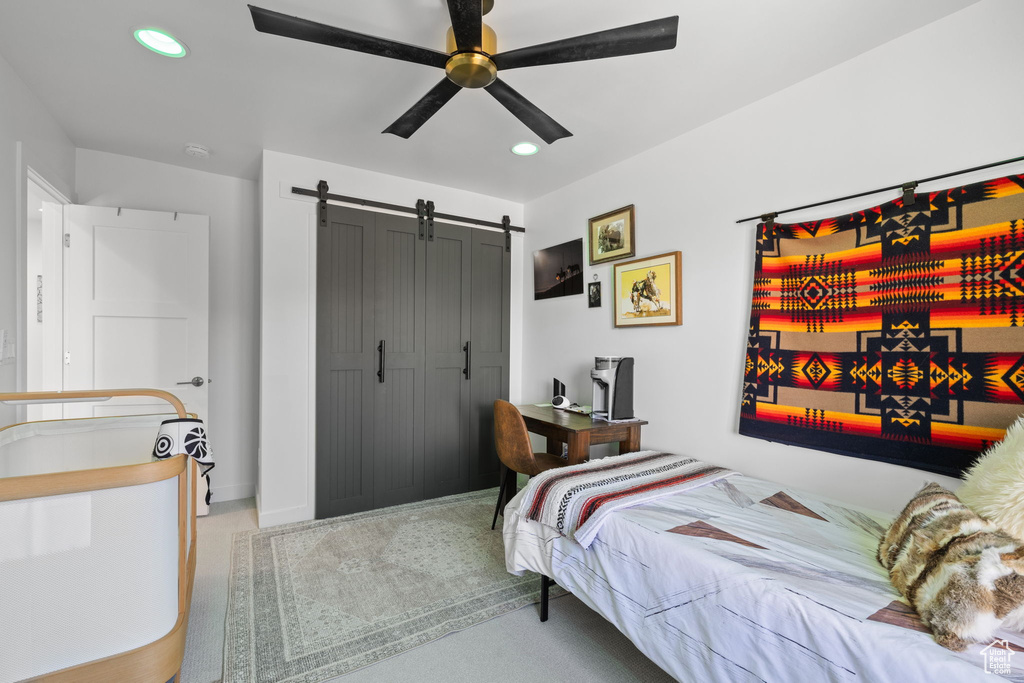 Bedroom featuring recessed lighting, a barn door, a ceiling fan, and a closet