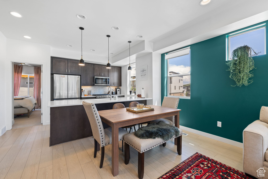 Dining room with recessed lighting and light wood-type flooring