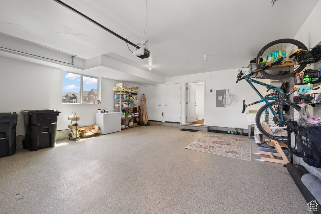 Garage featuring electric panel and a garage door opener