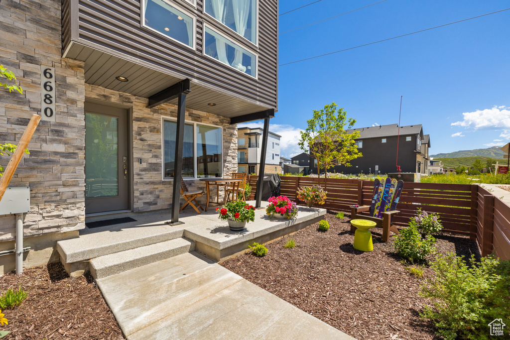 Entrance to property featuring stone siding and a patio