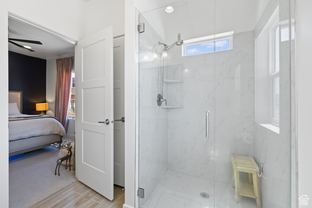 Bathroom featuring a marble finish shower, wood finished floors, ensuite bath, and ceiling fan