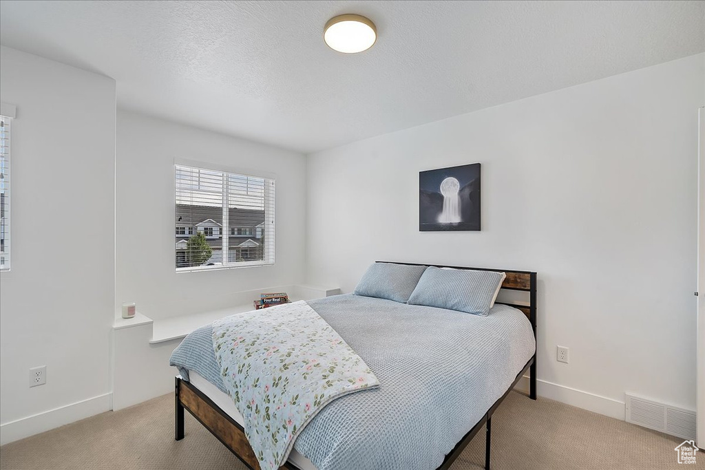 Bedroom featuring carpet and baseboards