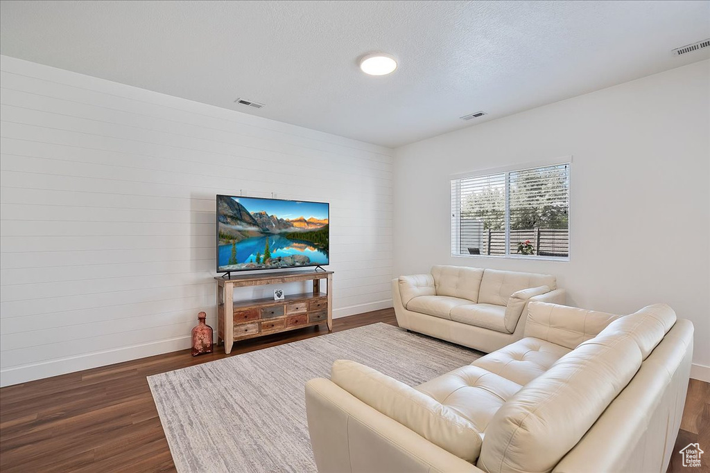 Living area featuring baseboards and dark wood finished floors