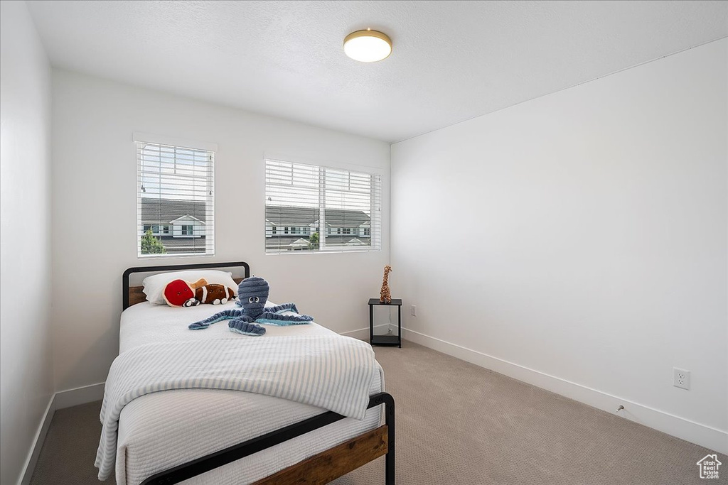 Bedroom with baseboards and light colored carpet
