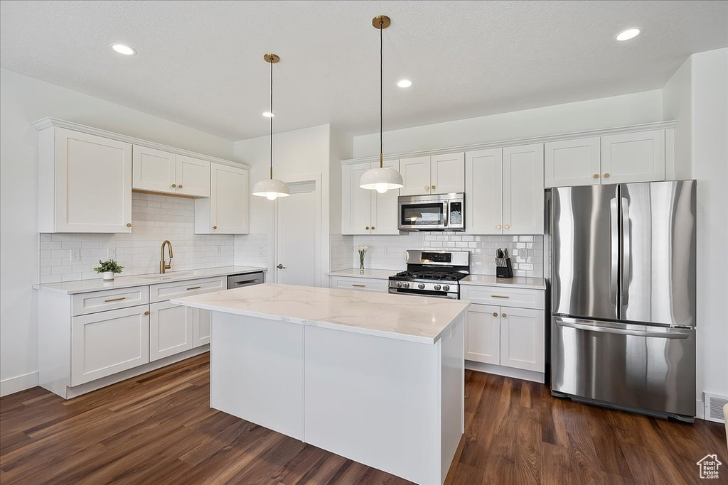 Kitchen featuring stainless steel appliances, dark wood-style flooring, white cabinetry, and recessed lighting