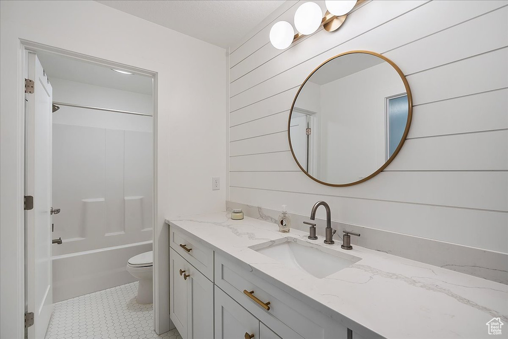 Full bathroom with vanity, bathtub / shower combination, wood walls, and tile patterned floors
