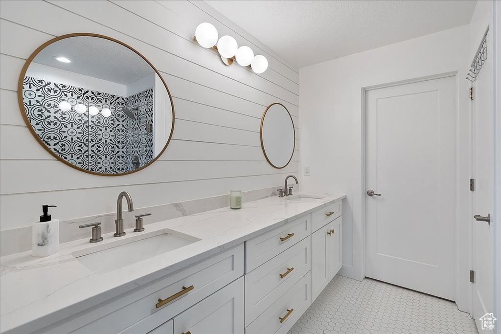 Full bath featuring double vanity and wood walls