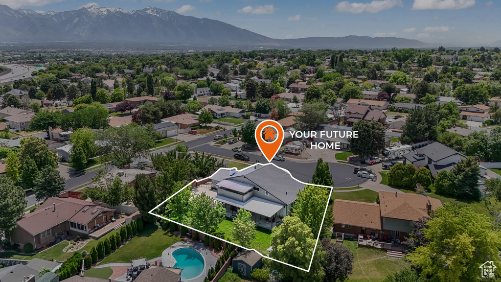 Aerial view of residential area with a mountainous background and property parcel outlined