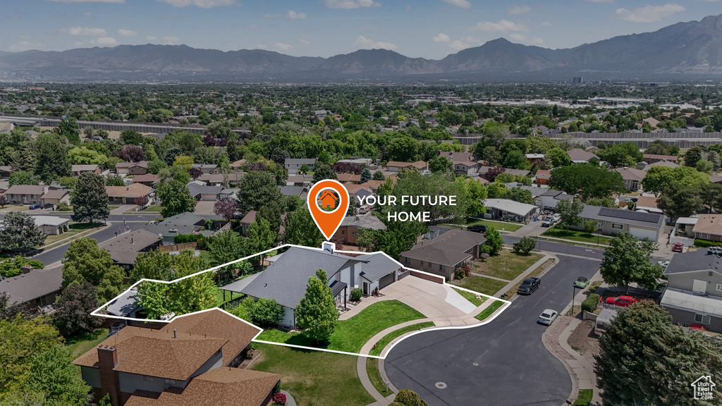 Aerial perspective of suburban area featuring a mountainous background and property parcel outlined