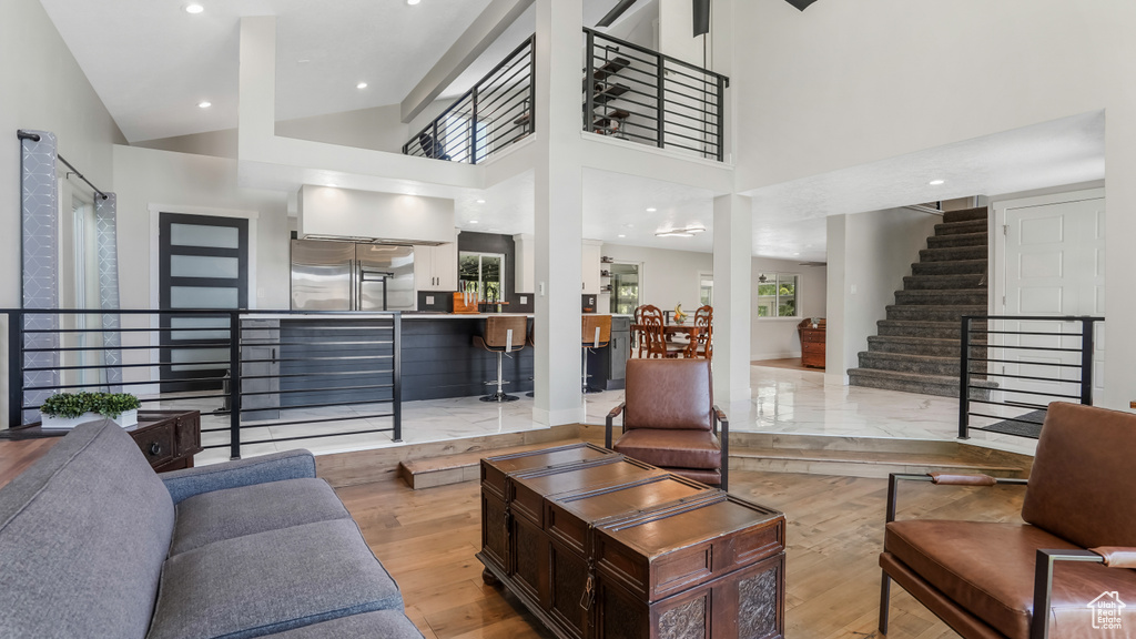 Living room with stairs, wood finished floors, and recessed lighting