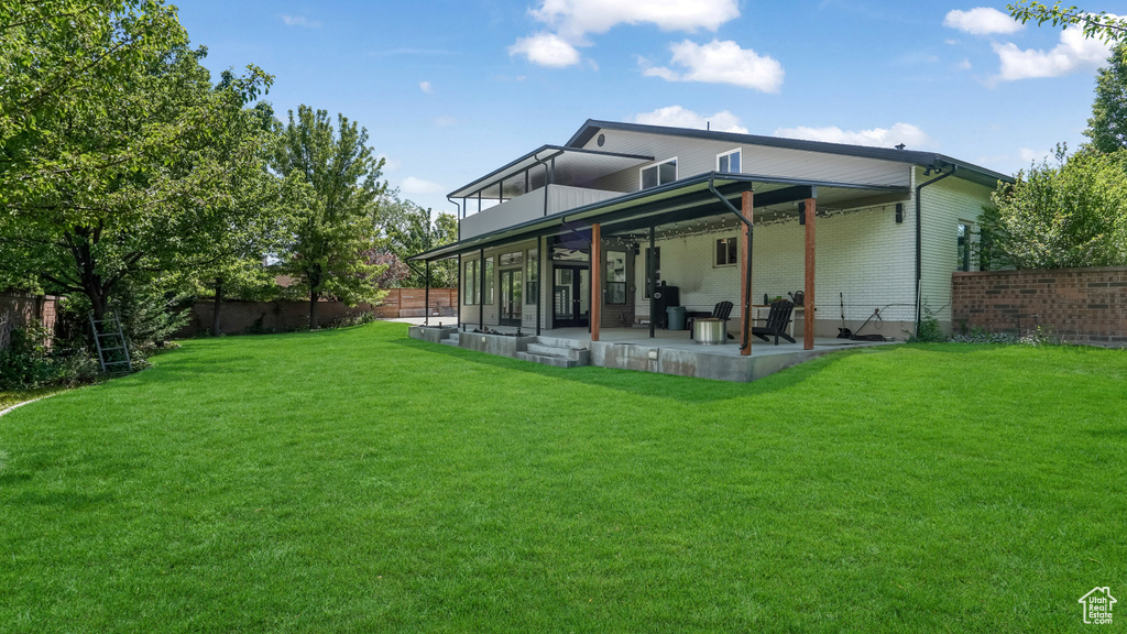 Rear view of house with a patio, a fenced backyard, and brick siding
