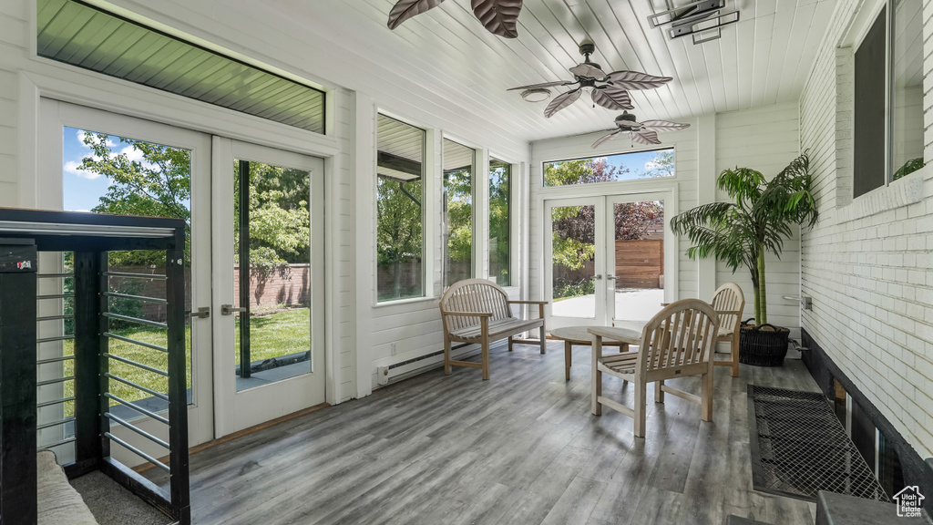 Sunroom / solarium with french doors, plenty of natural light, and ceiling fan