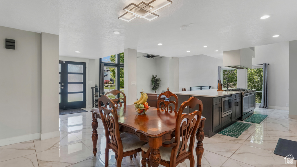 Dining room featuring recessed lighting, a ceiling fan, and light marble finish floors