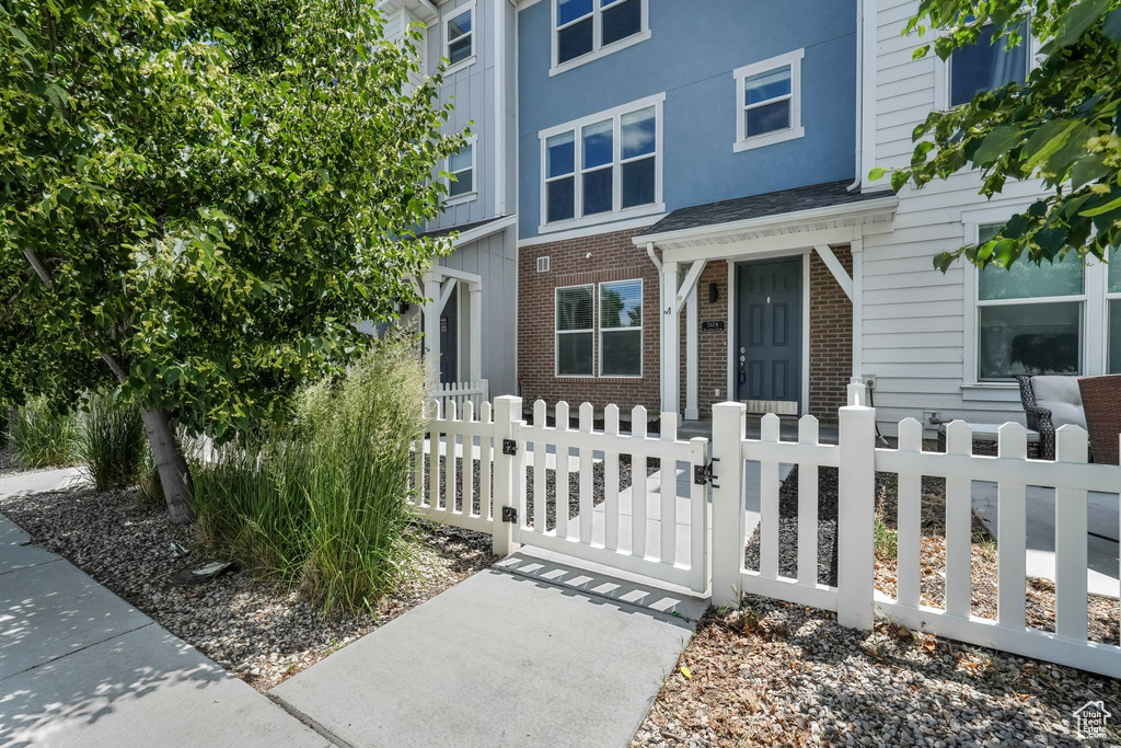 View of front facade with a gate, a fenced front yard, and brick siding