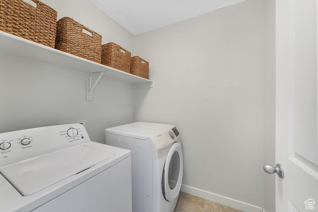 Laundry room featuring washing machine and dryer and baseboards