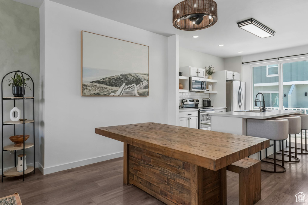 Kitchen with appliances with stainless steel finishes, open shelves, white cabinets, dark wood-type flooring, and recessed lighting
