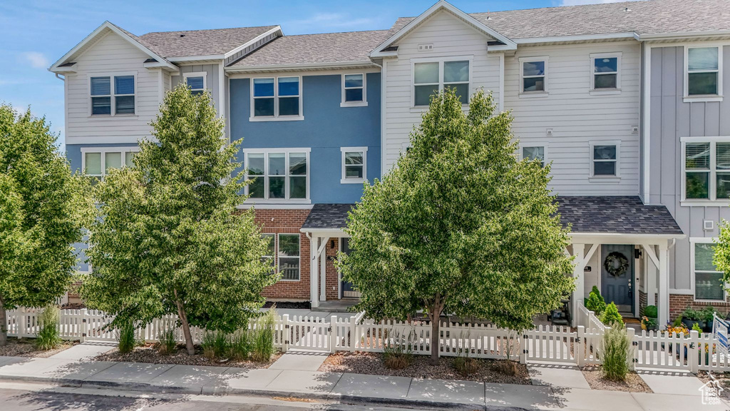 Townhome / multi-family property with a gate, brick siding, and board and batten siding