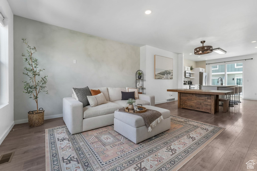 Living area featuring wood finished floors, recessed lighting, and a chandelier