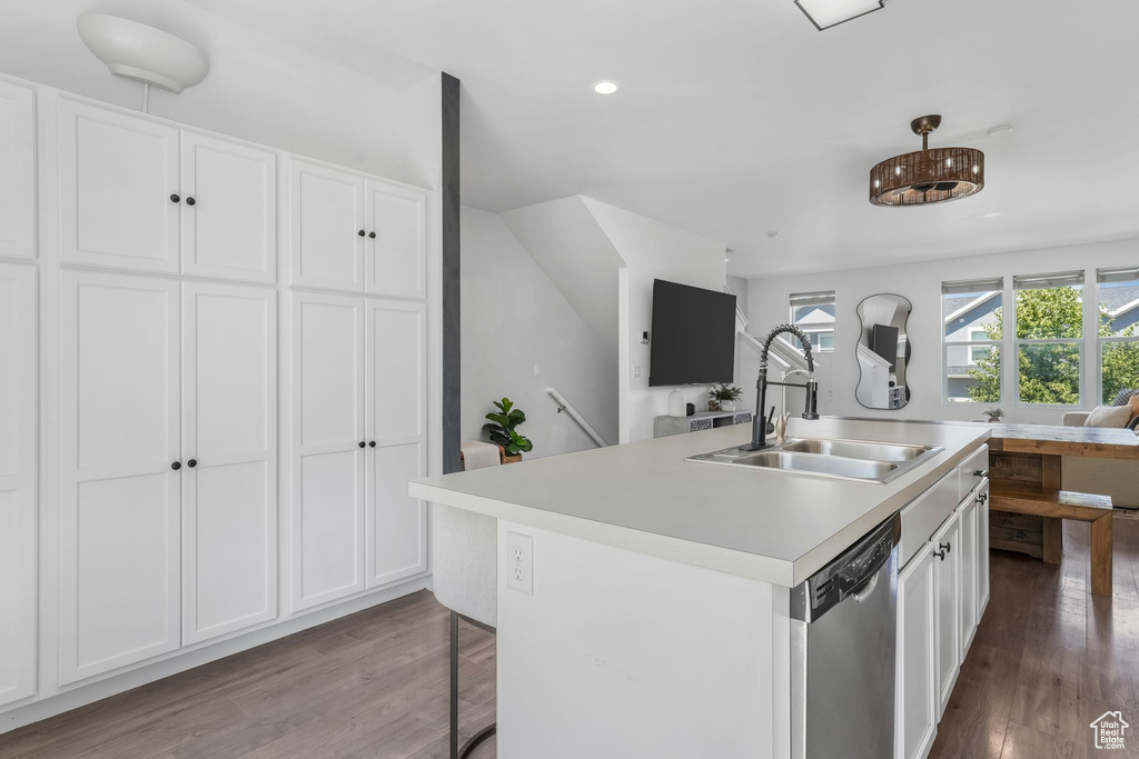 Kitchen featuring dishwasher, open floor plan, white cabinetry, wood finished floors, and recessed lighting