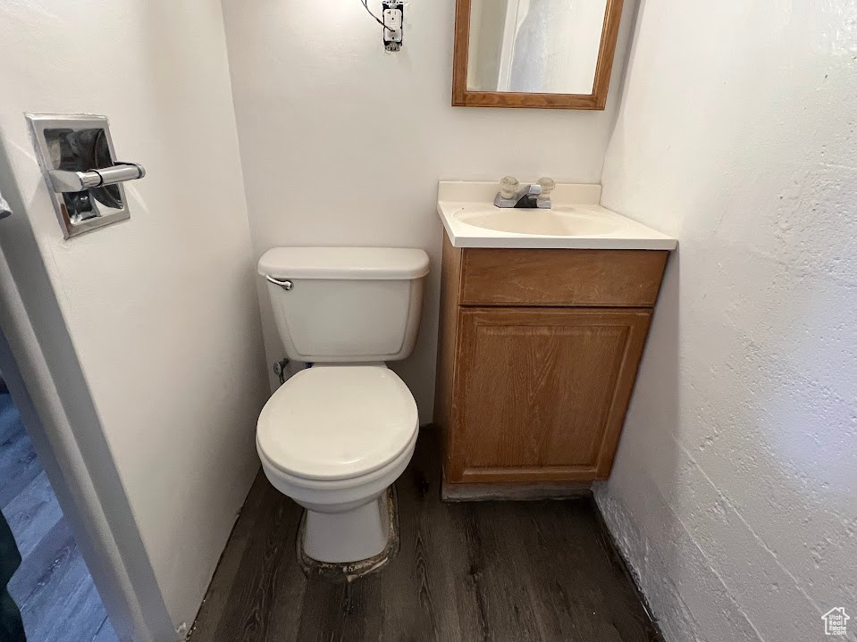 Half bath featuring wood finished floors and vanity