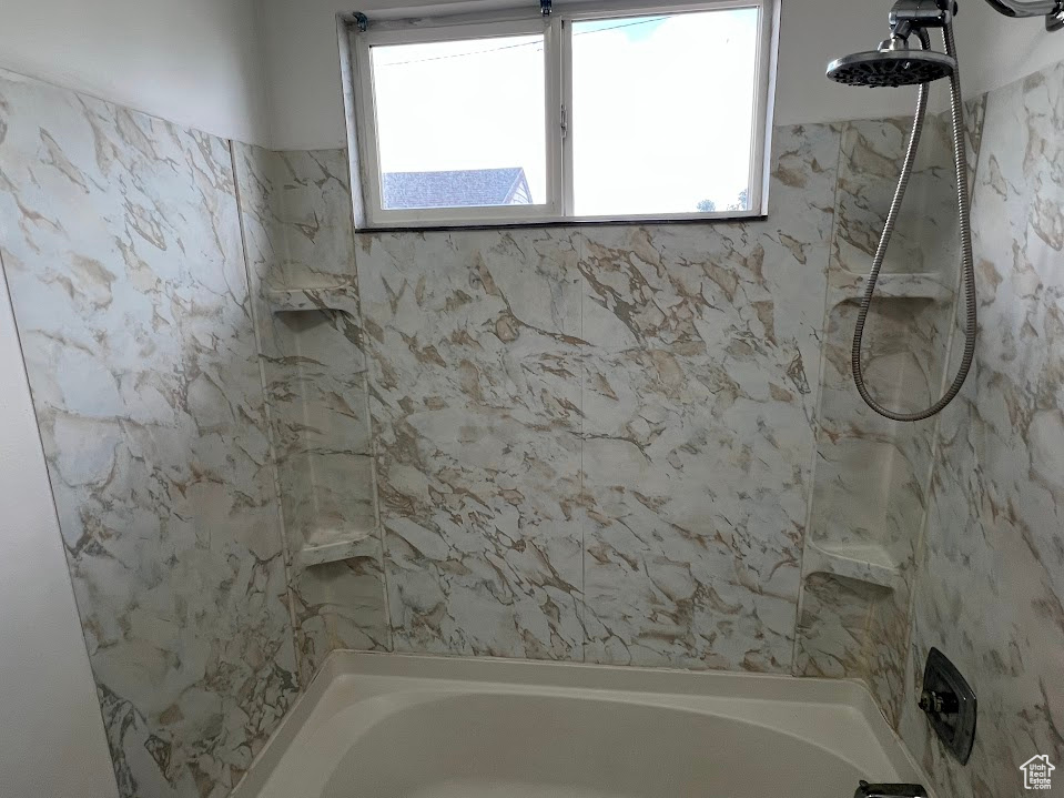 Bathroom with a combined bath / shower with marble appearance
