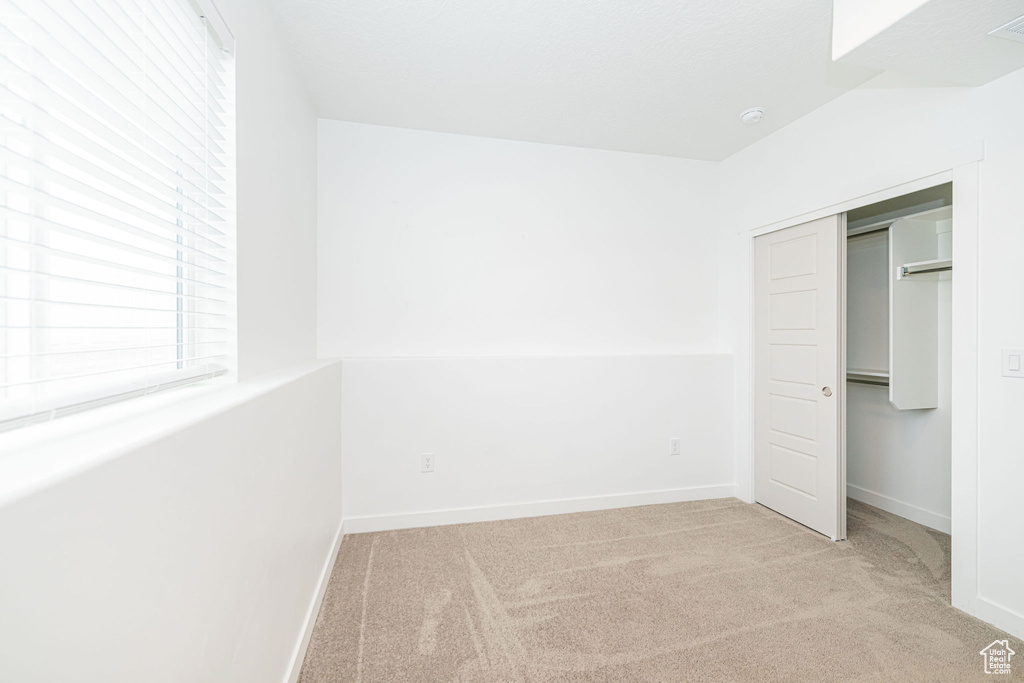Unfurnished bedroom featuring carpet and a closet
