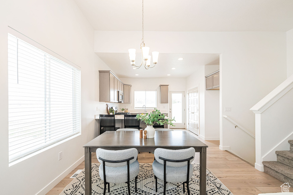 Dining area featuring a chandelier, stairway, light wood finished floors, and recessed lighting