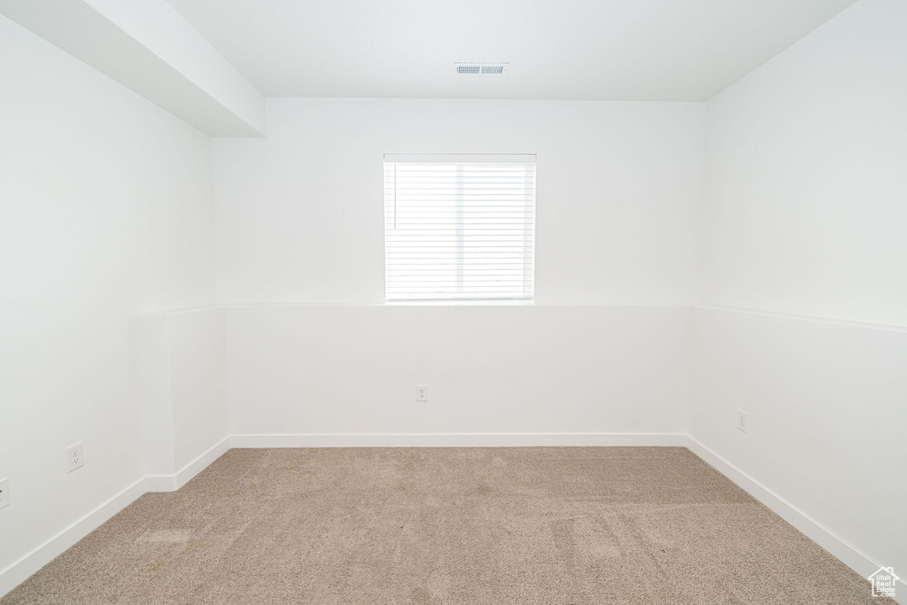 Unfurnished room featuring light colored carpet and baseboards