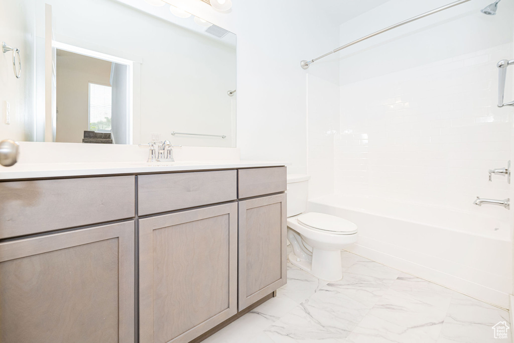 Full bathroom with marble look tiles,  shower combination, and vanity
