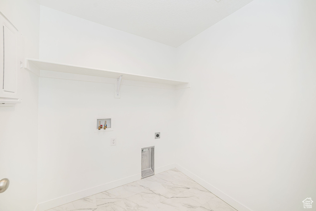 Laundry room featuring washer hookup, light marble finish floors, and electric dryer hookup