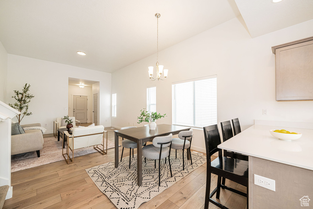 Dining area featuring light wood-style floors, recessed lighting, and a chandelier