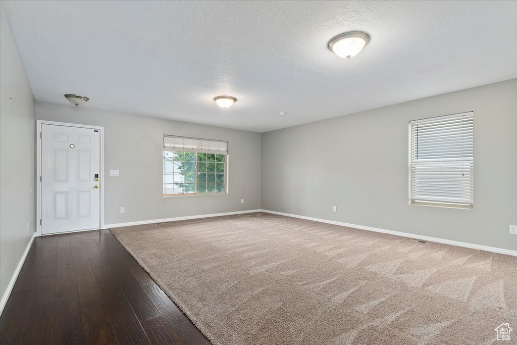 Unfurnished room with dark wood-type flooring and a textured ceiling