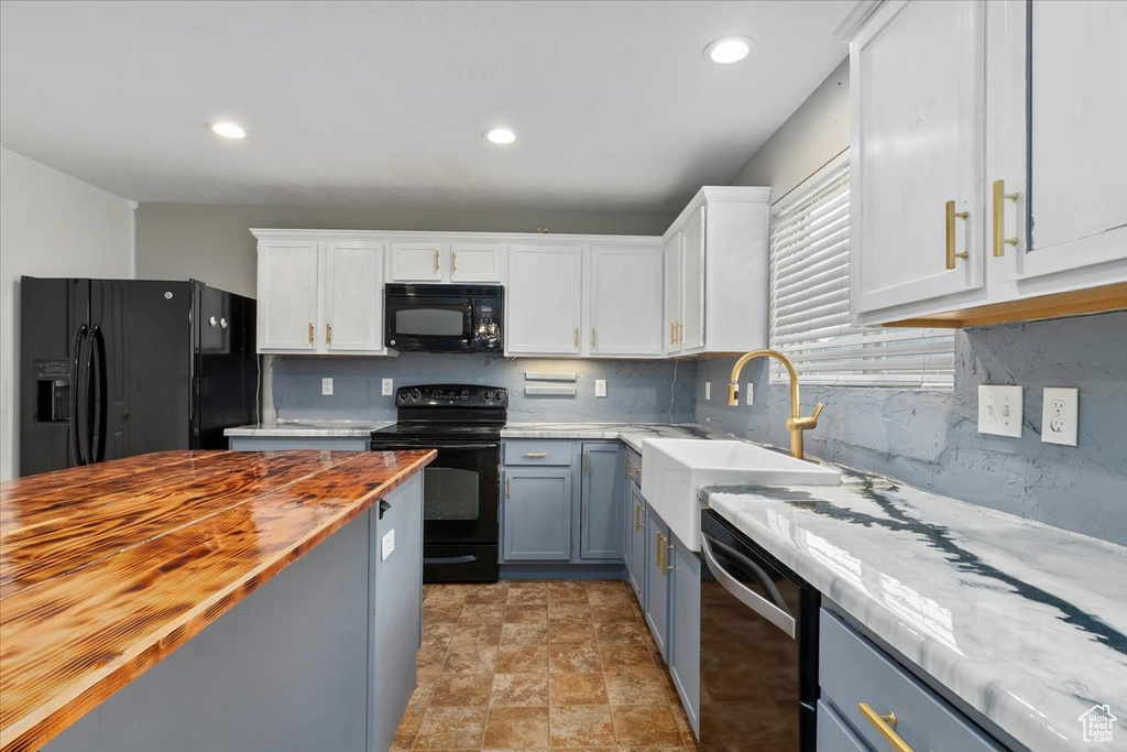 Kitchen featuring black appliances, wood counters, decorative backsplash, white cabinets, and recessed lighting