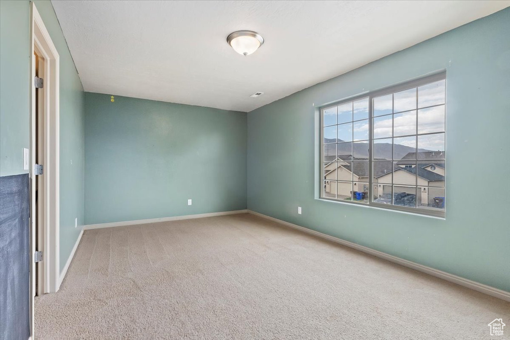 Empty room featuring carpet and baseboards