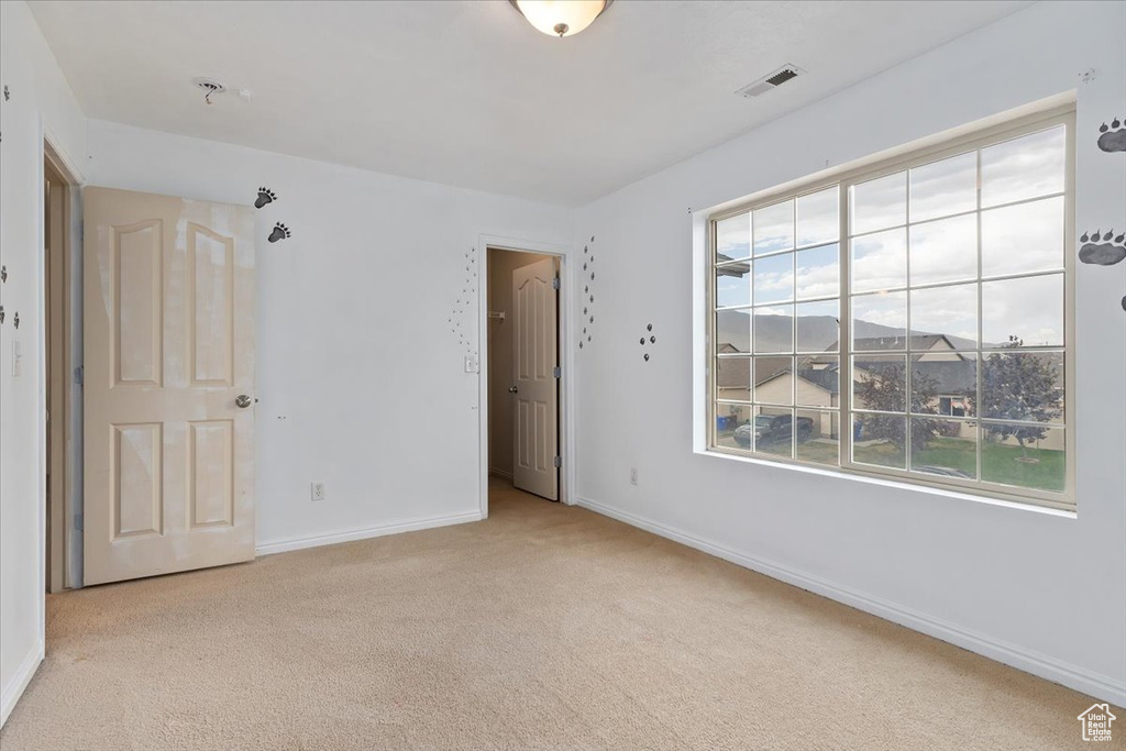 Empty room featuring carpet and baseboards