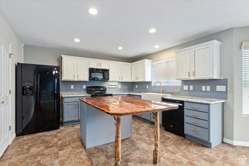 Kitchen with black appliances, wooden counters, white cabinets, backsplash, and recessed lighting