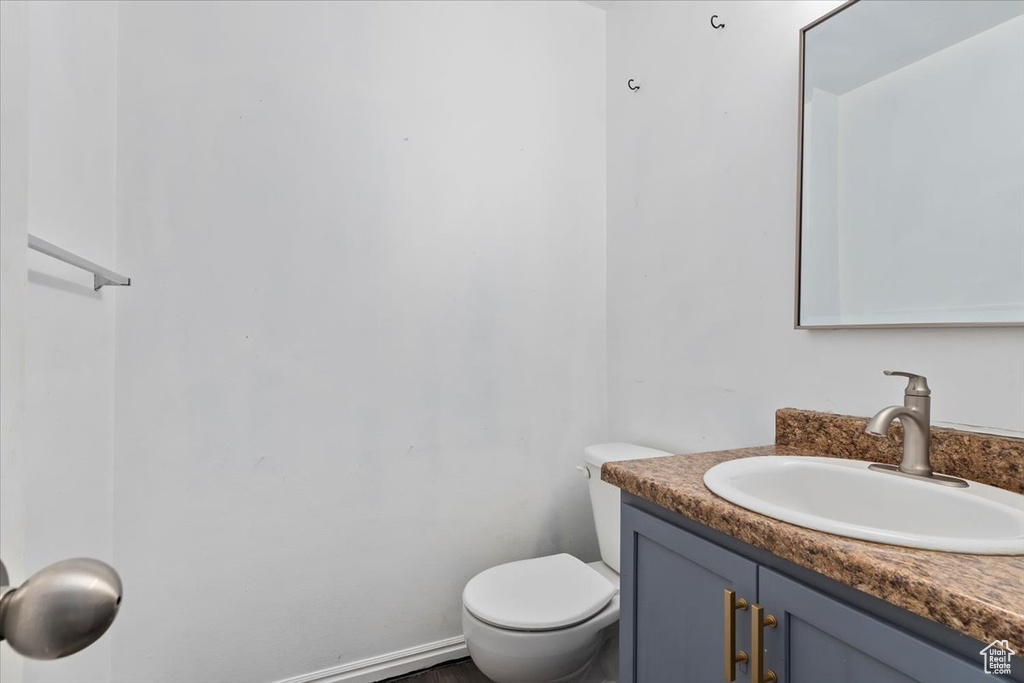 Half bathroom featuring vanity and toilet