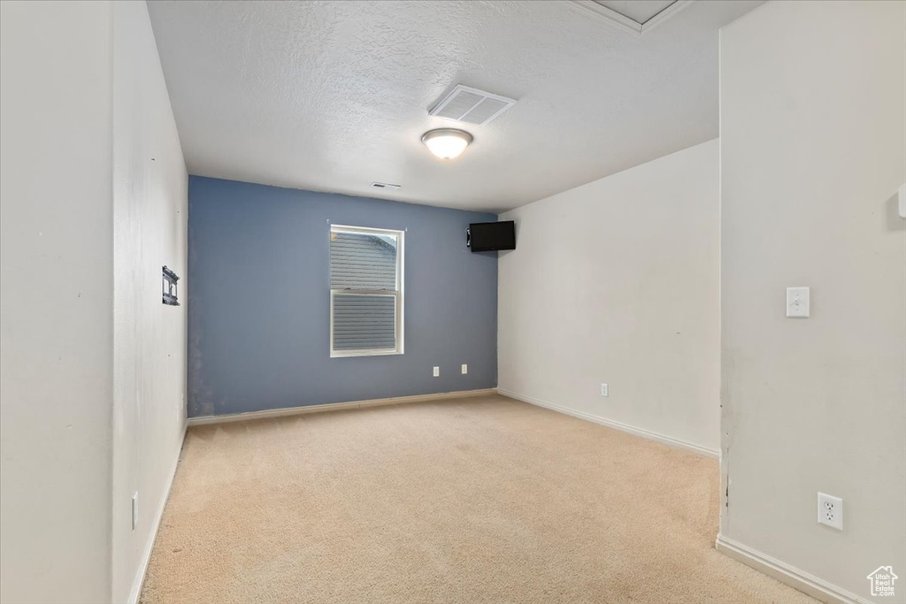 Empty room with carpet flooring and a textured ceiling