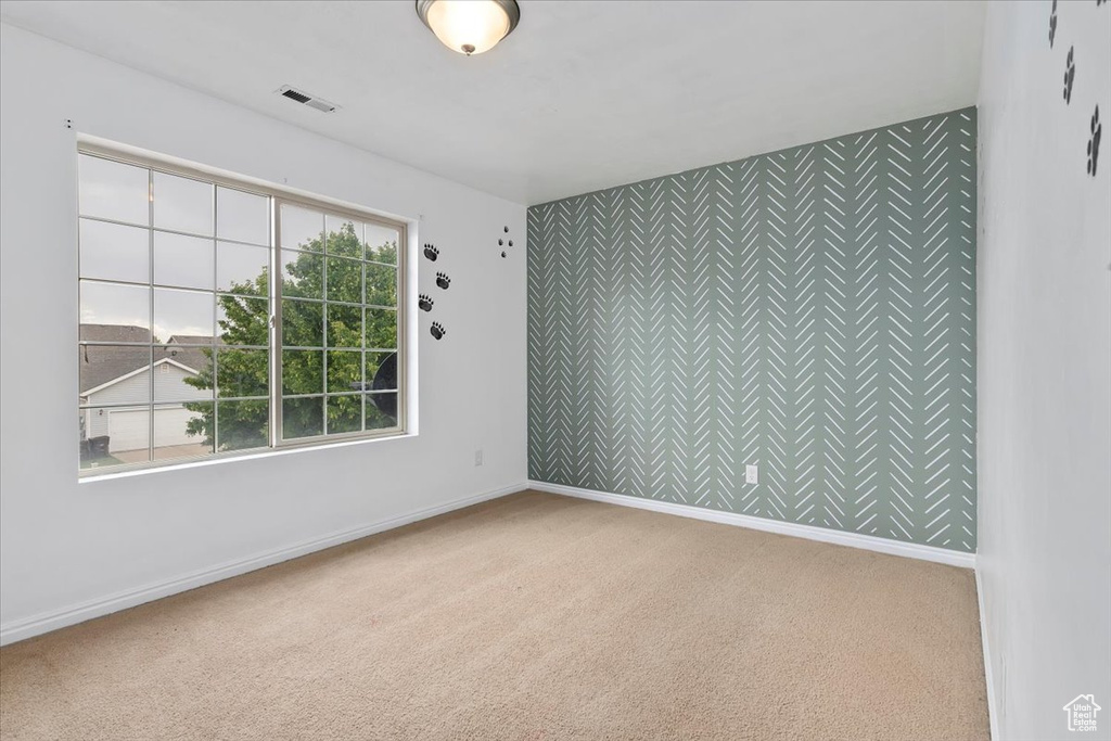 Empty room with carpet floors and an accent wall