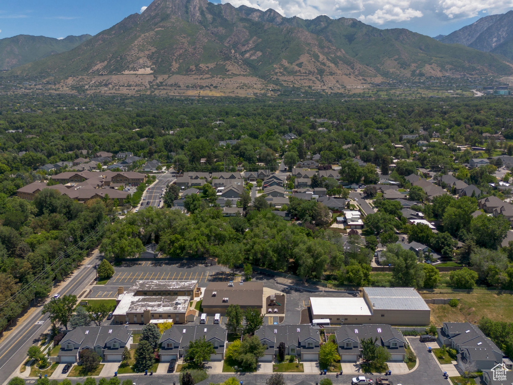 Aerial view of property and surrounding area with nearby suburban area and mountains