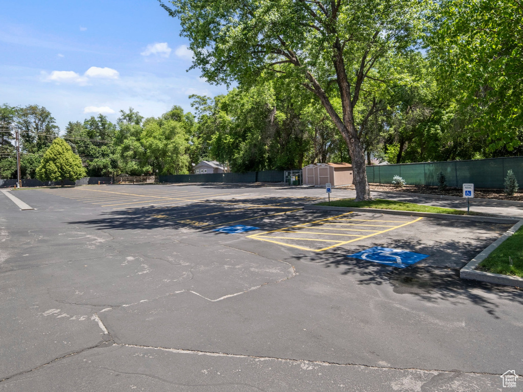 Uncovered parking lot featuring view of wooded area