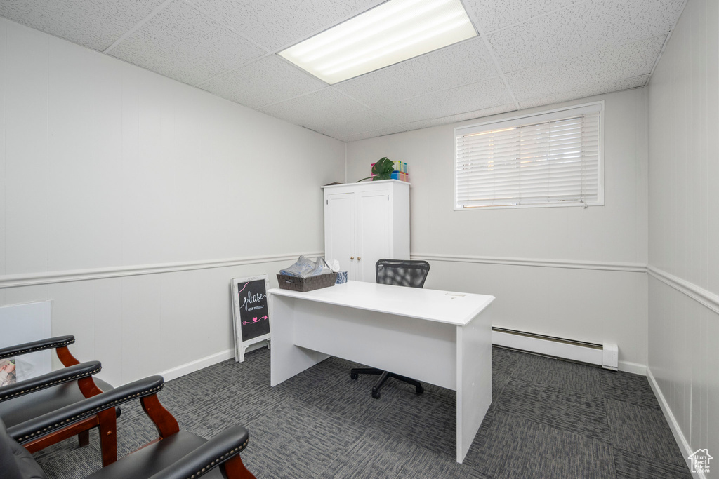 Office space featuring a baseboard heating unit, a drop ceiling, and carpet floors